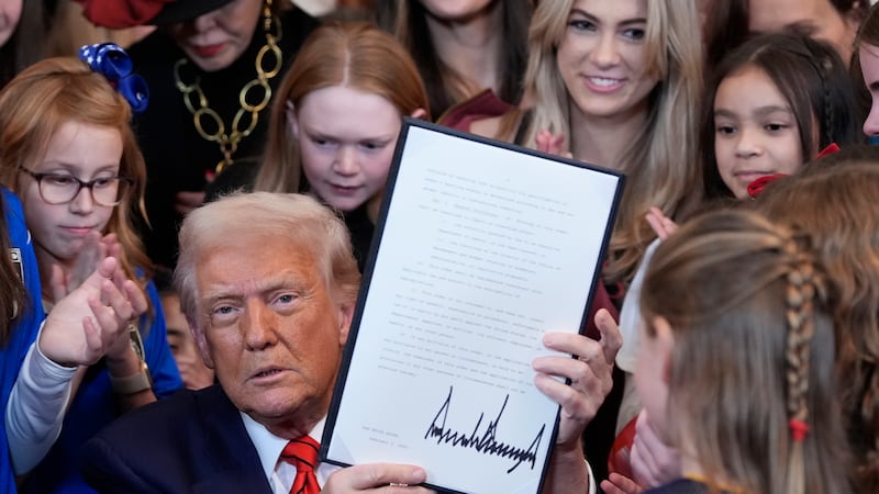 President Donald Trump signs an executive order barring transgender female athletes from...