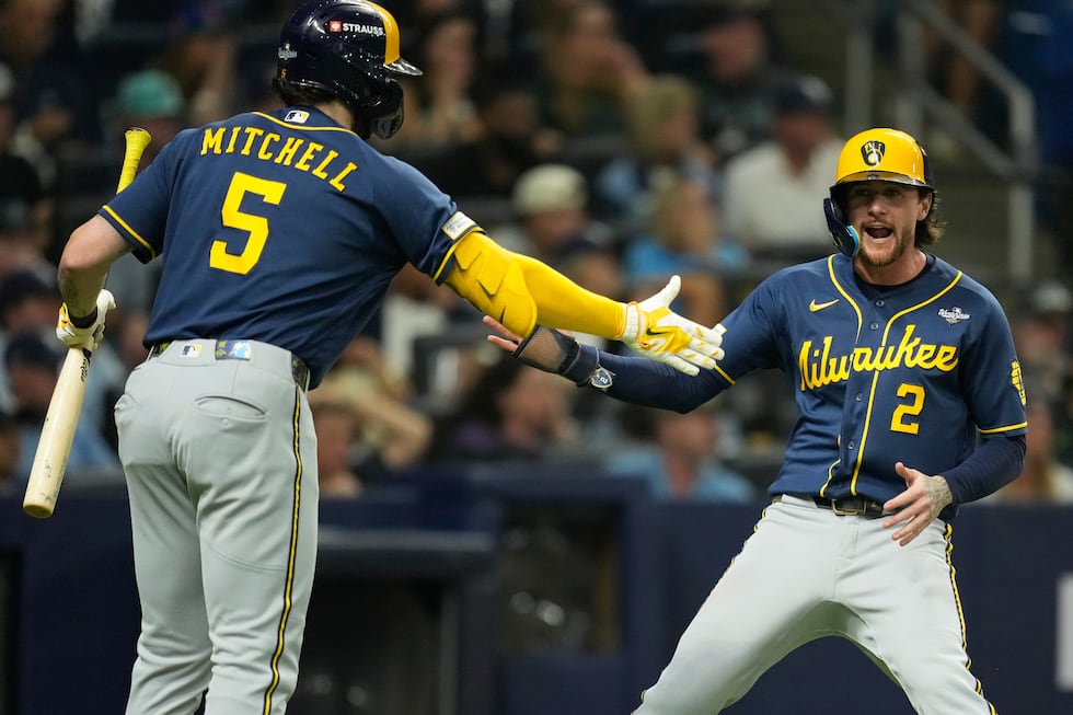Milwaukee Brewers' Brice Turang celebrates after scoring on a single by Cooper Pratt during...