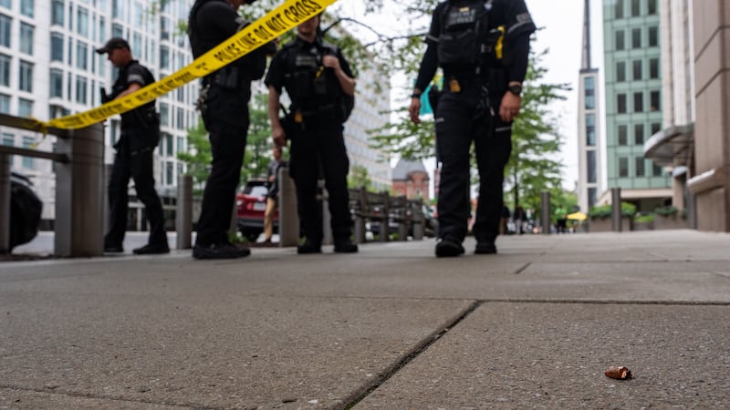 U.S. Secret Service Police officers place crime scene tape after a copper jacket of a bullet...